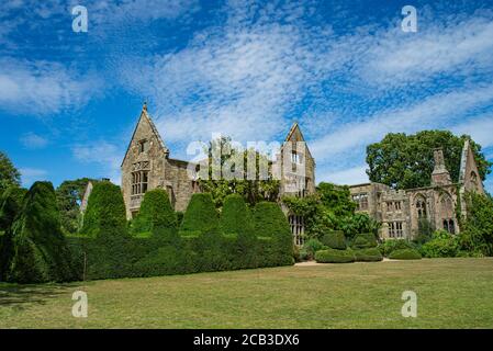 Le rovine di Nymans casa con gli alberi di fronte alla casa in un giorno d'estate. Haywards Heath, West Sussex, Inghilterra. Foto Stock