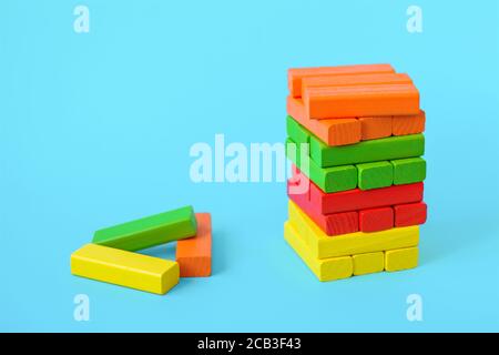 Blocchi jenga colorati su sfondo blu, gioco torre Foto Stock