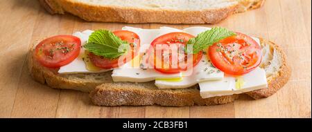 Panino vegetariano con pane fatto in casa, pomodoro, formaggio fresco e olio d'oliva. Alimentazione sana, dieta Foto Stock