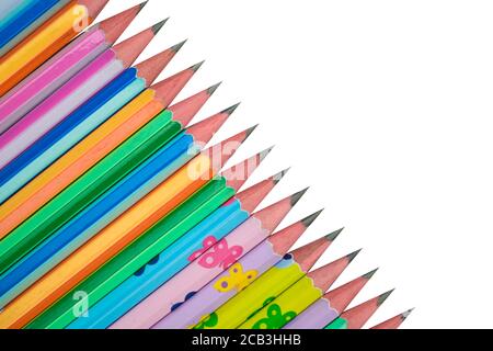 Pila di differenti pastelli colorati di matita di legno messi su un sfondo di carta bianca Foto Stock