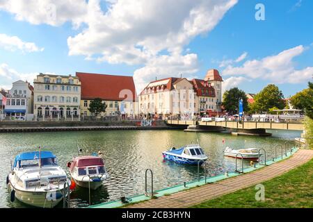Il colorato villaggio costiero Baltico di Warnemunde Rostock, in Germania, con le barche nel canale Alter Strom e i turisti che si godono una giornata estiva. Foto Stock
