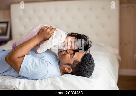 felice padre abbracciando il suo dolce bambino, amore tra una figlia e un papà, primo piano vista laterale foto Foto Stock