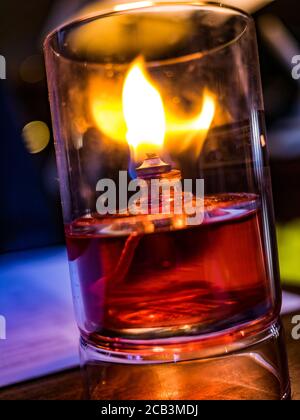 Candela che brucia in un vetro trasparente Foto Stock