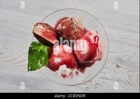 Trio di gustosa vaniglia al cioccolato e dessert surgelato al gusto di fragola in una ciotola blu con due paillette di wafer. Foto Stock