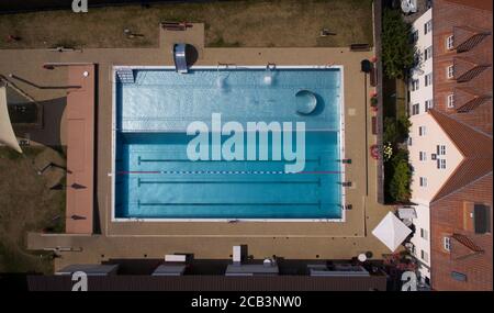 Borgholzhausen, Germania. 10 agosto 2020. La fotografia aerea di un drone mostra una piscina deserta. A causa della mancanza d'acqua, la piscina all'aperto nel quartiere di Gütersloh rimarrà chiusa fino a nuovo avviso. Poiché l'acqua a Borgholzhausen è diventata scarsa dopo il calore estivo continuato con l'aumento del consumo di acqua e le poche piogge delle ultime settimane, una chiusura temporanea della piscina è diventato inevitabile, la homepage dell'autorità locale ha detto. Credit: Friso Gentsch/dpa/Alamy Live News Foto Stock