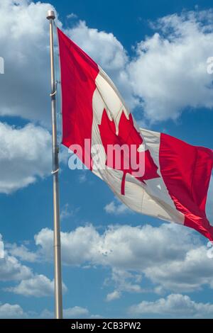 Foglia d'acero bandiera del Canada su uno sfondo di blu cielo con nuvole Foto Stock