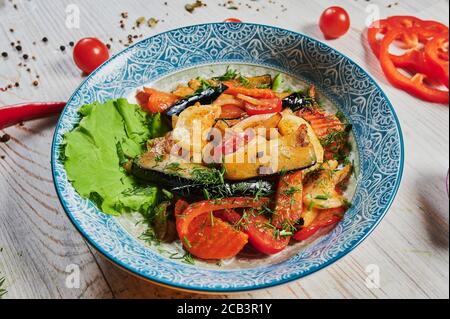 Verdure grigliate Veggy Succulent con peperoni dolci assortiti, midollo e pomodoro guarniti con erbe servite in un piatto con ingredienti visibili Foto Stock