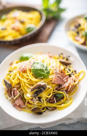 Pasta italiana spaghetti prosciutto funghi parmigiano e olio d'oliva Foto Stock