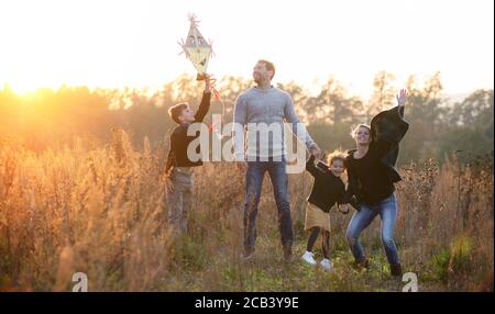 Bella giovane famiglia con bambini piccoli che si divertono nella natura autunnale. Foto Stock