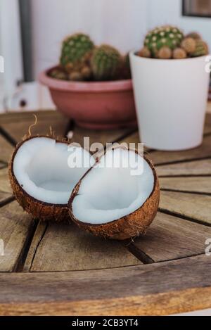 Metà Coconuts: Fuoco selettivo di fresco gustoso metà cocco su tavolo di legno, all'aperto, nessuno Foto Stock