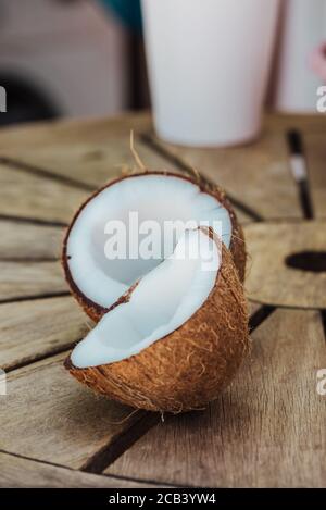 Metà Coconuts: Fuoco selettivo di fresco gustoso metà cocco su tavolo di legno, all'aperto, nessuno Foto Stock