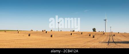 campi dopo la raccolta nel nord della francia con vento turbine in background Foto Stock