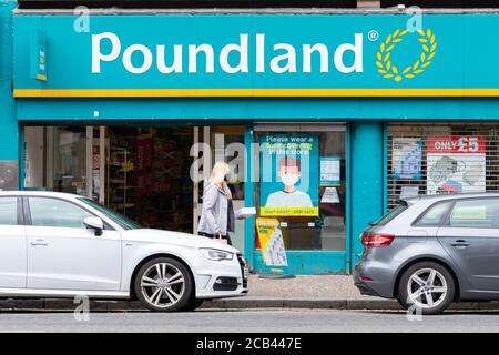 Negozio Poundland che chiede agli acquirenti di indossare mascherine coprenti durante la pandemia del coronavirus, Anniesland, Great Western Road, Glasgow, Scotland, UK Foto Stock