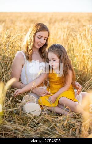 Bella giovane madre e sua figlia al campo di grano in giornata di sole, repubblica Ceca Foto Stock