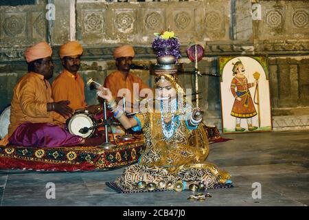 Udaipur, India - 24 maggio 2013: Una donna indiana con vaso di terra sul fuoco che bilancia sulla loro testa mentre esegue il danceord di Rajasthani Foto Stock