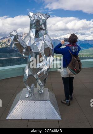 Persona cellulare fotocamera specchio portare la statua in cima edificio su Sulphur Mountain nelle Montagne Rocciose, Banff, Alberta, Canada Foto Stock