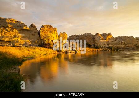 I hoodoos e le scogliere di arenaria si riflettono nel fiume latte, scrivendo sullo Stone Provincial Park, Alberta, Canada Foto Stock