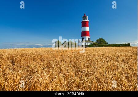 Happisburgh, Norfolk, il faro a strisce rosse e bianche contro un cielo blu Foto Stock
