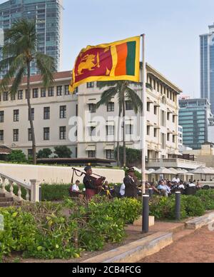dh Galle Face Hotel COLOMBO CITY SRI LANKA Hotel sera Abbassamento della bandiera dello Sri Lanka con il bagpiper Foto Stock