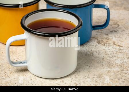 tazza di tè caldo in smalto metallico su piastrelle in ceramica sfondo Foto Stock