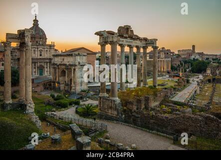 Il sole sorge sul Forum di Roma. Il Colosseo è visibile sullo sfondo a destra della foto Foto Stock