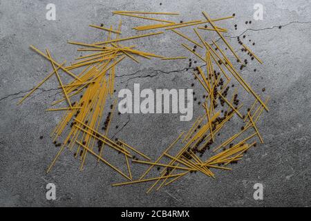 Pasta gialla su sfondo grigio. Spaghetti su fondo cementizio. Spaghetti bolognesi crudi. Concetto di fondo alimentare. Vista dall'alto Foto Stock