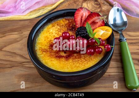 Cucina turca varietà di dessert. Muhallebi / Pudding fatto in casa. Budino di riso al forno latte turco dessert sutlac in casseruola di terracotta con foresta f Foto Stock