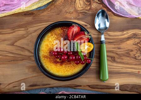 Cucina turca varietà di dessert. Muhallebi / Pudding fatto in casa. Budino di riso al forno latte turco dessert sutlac in casseruola di terracotta con foresta f Foto Stock