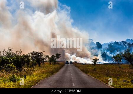 Colline di Matobo, strada di campagna e campi agricoli in fiamme, Matobo National Park, sobborghi di Bulawayo, Matabeleland Sud, Zimbabwe, Africa Foto Stock