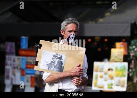 Parigi, Francia. 10 agosto 2020. Un artista di strada attende i clienti al Montmartre di Parigi, Francia, 10 agosto 2020. I casi della nuova infezione da coronavirus in Francia hanno superato 200,000 lunedì, con 4,854 nuove infezioni confermate negli ultimi tre giorni. Il totale dei casi confermati è salito a 202,775 e 332 gruppi sono ancora attivi, secondo gli ultimi dati pubblicati dal Ministero della Sanità. Credit: Gao Jing/Xinhua/Alamy Live News Foto Stock