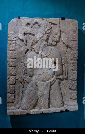 Una tavoletta di pietra scolpita che rappresenta un capo di guerra catturato da Palenque nel museo alle rovine della città maya di Tonina, vicino a Ocosingo, Messico. Foto Stock