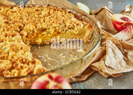 Torte fatte in casa, torta in una teglia con pesche e pere su cemento grigio-blu. Foto Stock