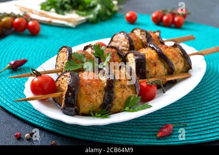 Polpette griled con melanzane su spiedini. Kebab di pollo con verdure. Piatto di carne dietetica. Foto Stock