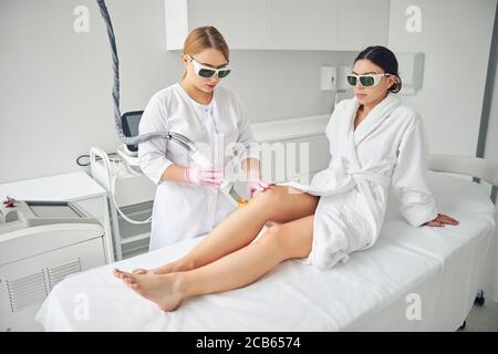 Cosmetologo professionista che esegue la rimozione dei capelli laser Foto Stock