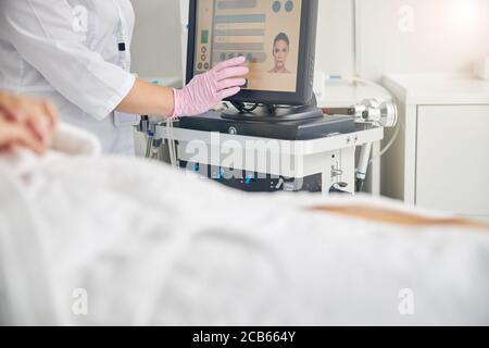 Mano del medico in un guanto di lattice su un touch screen Foto Stock