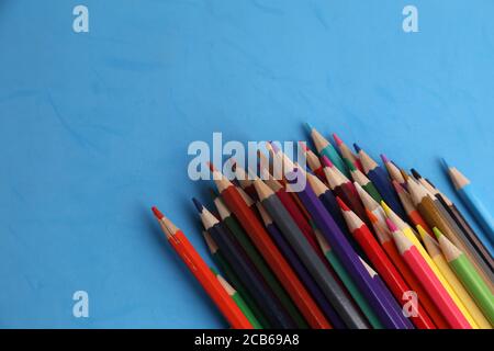 Primo piano di matite colorate su sfondo blu Foto Stock
