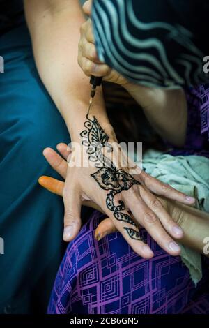 Fes, Marocco, Nord Africa. Tatuaggio henné a disposizione di un turista. Foto Stock