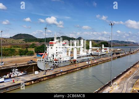 Rimorchiatore nascosto dietro una nave più grande nella serratura di Miraflores, canale di Panama, Panama Foto Stock