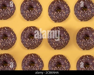 Ciambelle di cioccolato con motivo di mandorla su sfondo giallo Foto Stock