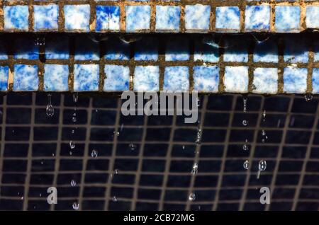 caduta gocce d'acqua da muro con piastrelle vintage primo piano sfondo astratto Foto Stock