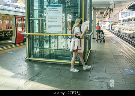 LONDRA, Regno Unito - 11 agosto 2020. Un passeggero sulla London Underground plaftorm che utilizza un ventilatore per raffreddarsi dalle condizioni di calore e umidità durante l'attuale ondata di calore. Le temperature elevate dovrebbero rimanere fino a giovedì prima che le tempeste arrivino alla fine della settimana. Credit: amer Ghazzal/Alamy Live News Foto Stock