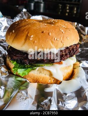 Hamburger di testy fresco con pomodori, formaggio, lattuga verde, cipolla e insalata. Foto Stock