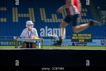Brunswick, Germania. 8 agosto 2020. Arbitro con protezione per bocca e naso guarda un atleta. Salto triplo uomo, su 08.08.2020 campionati tedeschi di atletica 2020, dal 08.08. - 09.08.2020 a Braunschweig/Germania. Â | utilizzo in tutto il mondo Credit: dpa/Alamy Live News Foto Stock