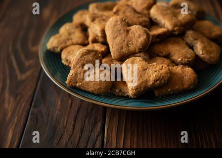 Primo piano biscotti fatti in casa integrale con farinata d'avena, uva passa, noci, semi e latte su fondo rustico di legno marrone. Concetto di alimentazione sana. Spazio di copia Foto Stock