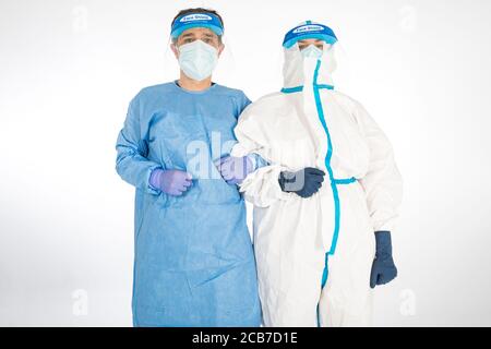 Uomo che indossa DPI e Donna medico che indossa DPI per combattere il coronavirus, tenendo per il braccio, su sfondo bianco. Guerriero. Concetto di medicina COVID Foto Stock