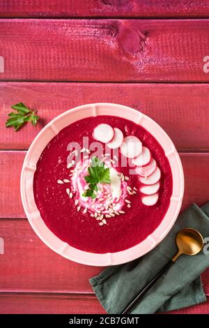 Colpo verticale di zuppa di barbabietole fredda estiva su legno rosso tabella Foto Stock