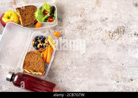 Vista dall'alto dei pranzi a scuola vegan con panini sani, insalate e frutta Foto Stock