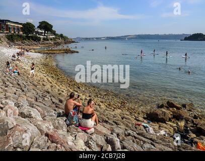 Bagno di Devil's Point sul lungomare di Stonehouse, Plymouth. I visitatori e la gente del posto apprezzano l'insolitamente calda giornata di agosto con le pagaie e il pa Foto Stock