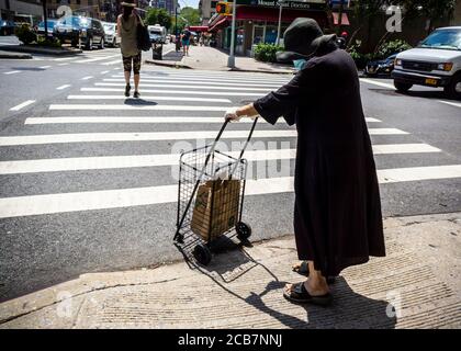 Una donna anziana attraversa un pericoloso incrocio di Eighth Avenue a Chelsea a New York mercoledì 5 agosto 2020. (© Richard B. Levine) Foto Stock