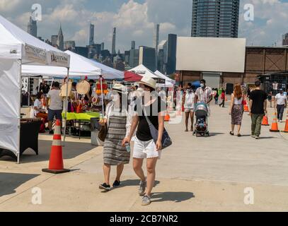 Gli acquirenti sopportano il caldo esplosivo al Greenpoint Terminal Market il giorno di apertura, domenica 9 agosto 2020. Il mercato ha mantenuto corsie extra larghe, un requisito per la copertura del viso e protocolli di distanza sociale come acquirenti navigato merci artigianali e antichi, nonché una selezione di fornitori di cibo. (© Richard B. Levine) Foto Stock